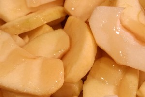 Die in Spalten geschnittenen Äpfel werden mit Honig beträufelt.